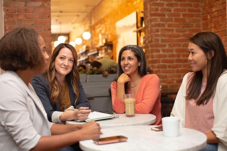 A group of women networking around a table