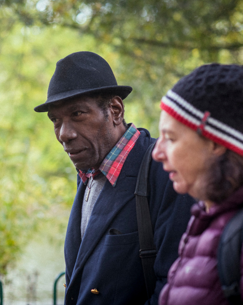 Man and woman wearing hats strolling around a park