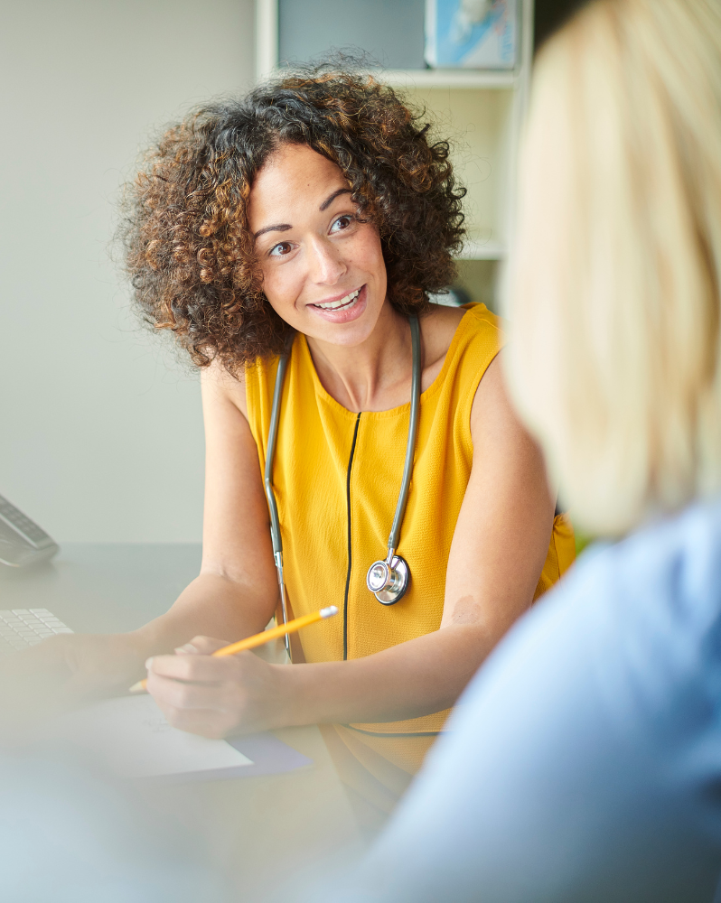 GP writing notes in a consultation with a patient