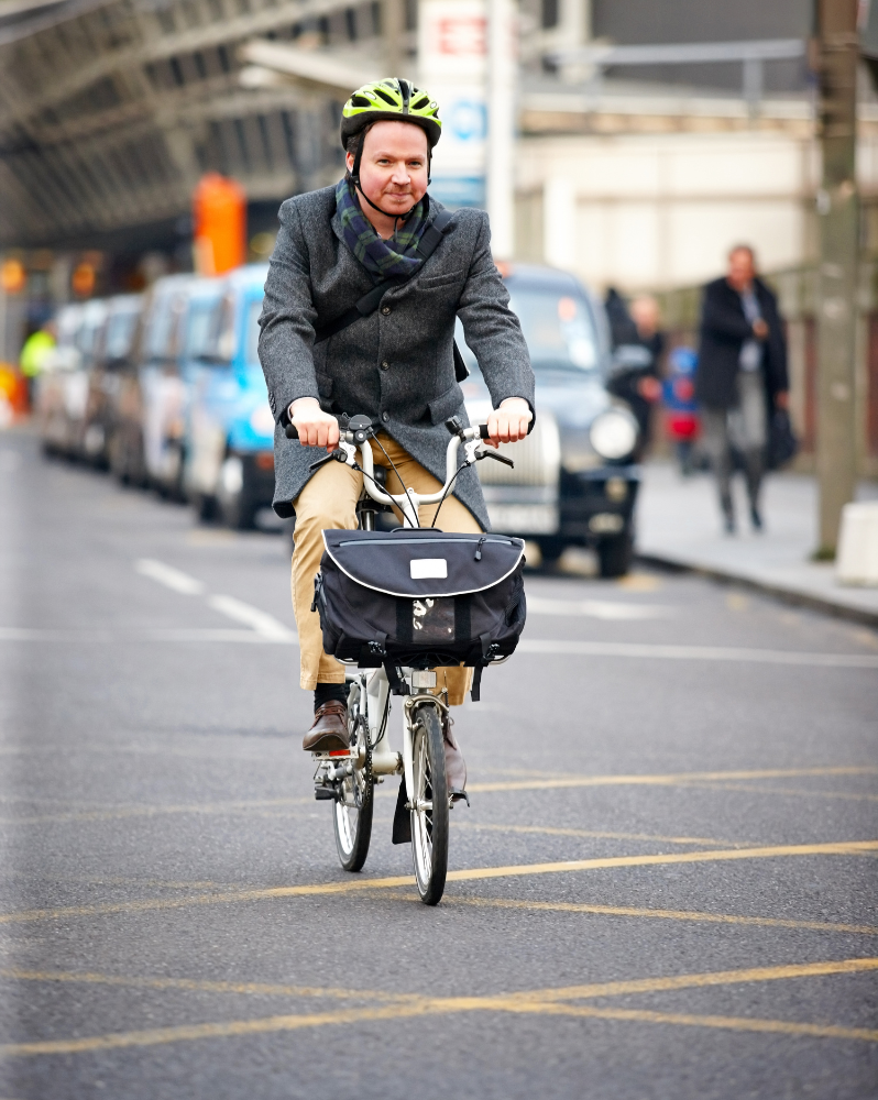 man cycling on commuter bike with helmet in London