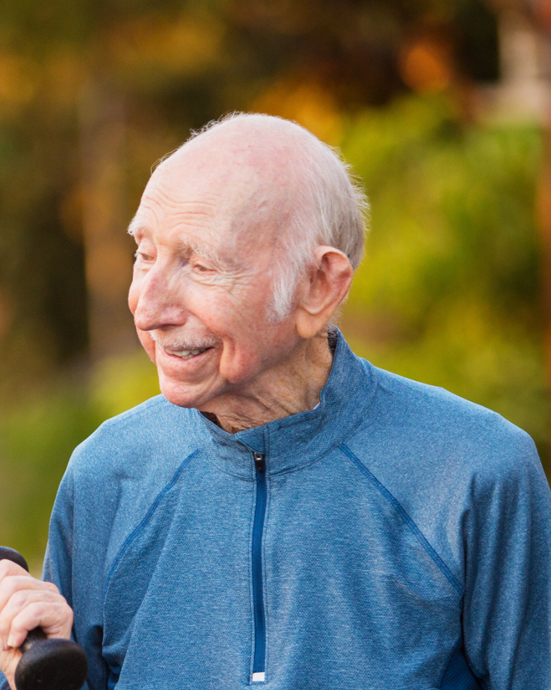 Older man in zipped top walking outdoors